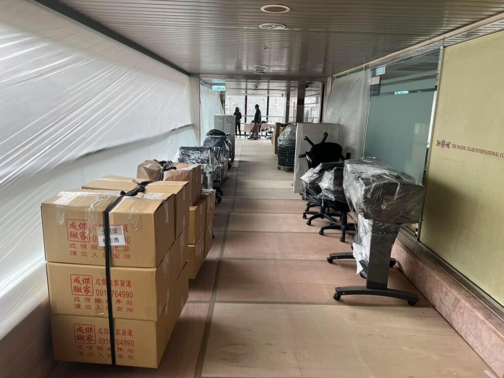 成傑搬家紙箱與辦公椅整齊排列走廊,地板鋪有保護墊,大規模辦公室搬遷作業