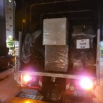 夜間廂型貨車尾板半開,車內可見標有物流標籤的包裝家具,回頭車搬家運送
