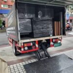 成傑搬家廂式貨車尾板開啟,車廂內以保鮮膜固定深色家具與木條,準備搬離