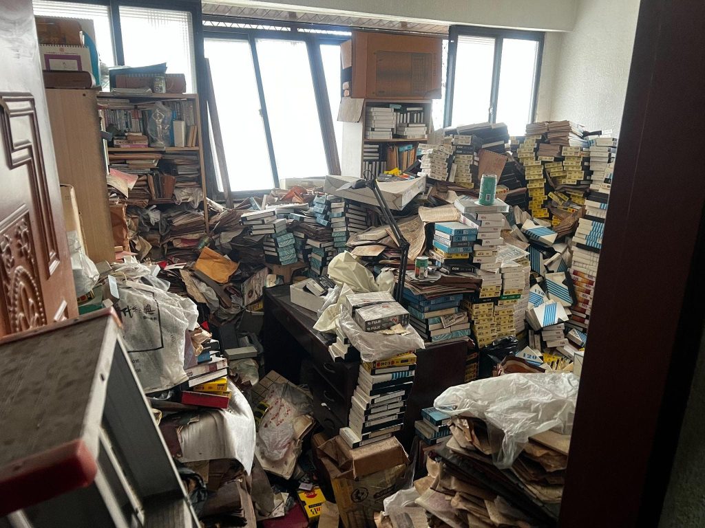 室內從地板到窗邊堆滿書籍、雜誌與廢棄物,搬家垃圾清運廢棄物處理前大量物品現場