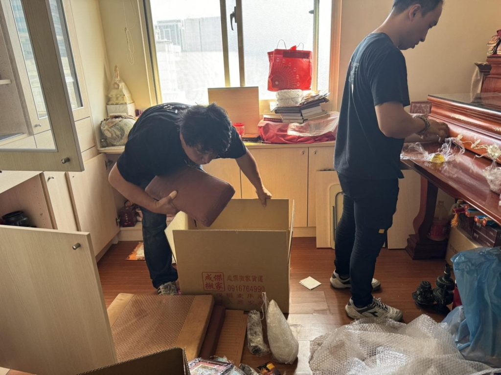 成傑搬家工作人員拆開品牌搬家紙箱，協助清點神明桌與書本等物品，家庭搬家開箱