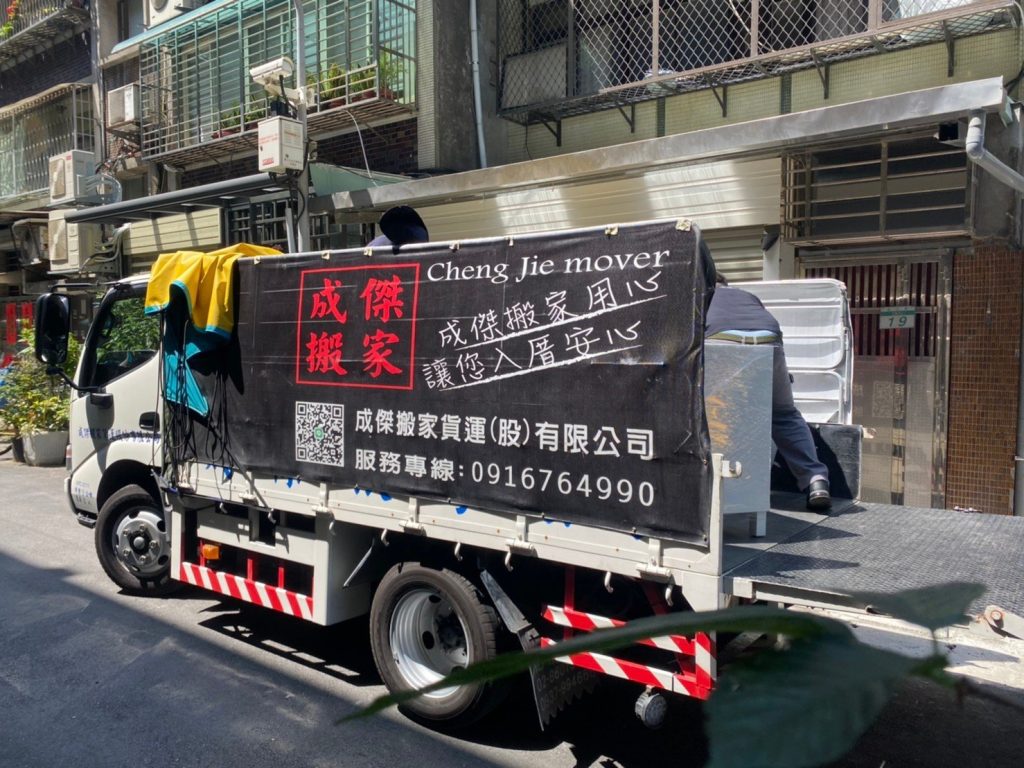 成傑搬家黑色貨運車停靠住宅巷弄,工作人員於車後進行家庭搬家裝卸作業