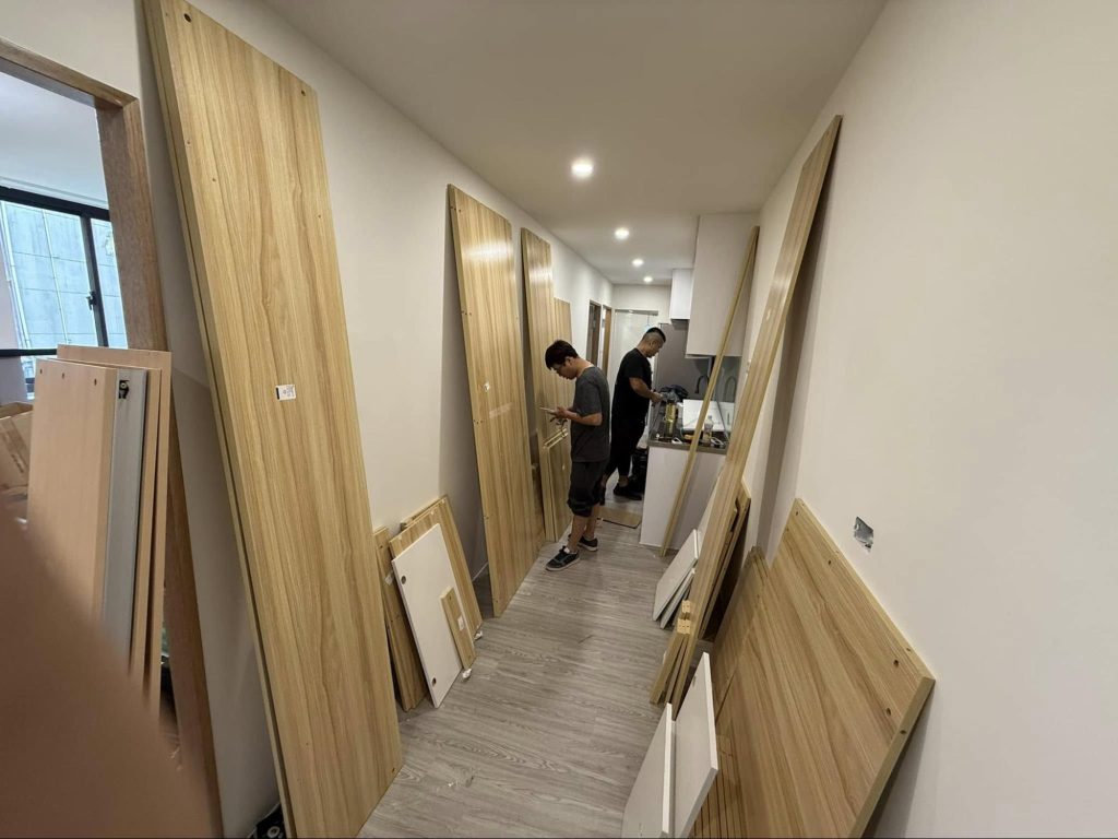 成傑搬家工人穿著品牌制服將大型木板抬上貨車,搬運大型物件現場